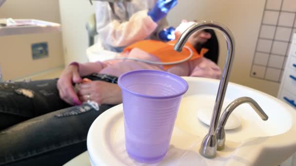 Frau in den 50er Jahren besucht Zahnklinik für professionelle Zahnbehandlung. Zahnärztin beugt sich über Patientin. Werkzeug des Arztes zur Mundreinigung. Professionelle Zahnschmerzkur. Stomatologie — Stockvideo