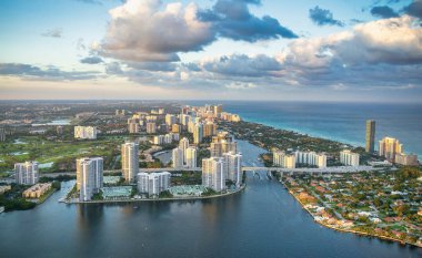 Florida 'da, gün batımında kıyı şeridi boyunca uzanan Miami Beach gökdelenlerinin Helciopter manzarası.