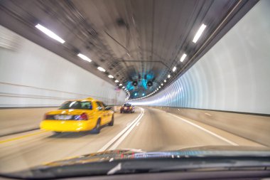 Miami tüneli boyunca hızla ilerleyen taksi, hızlı hareket bulanıklığı.