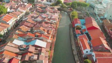 Melaka, Malezya. Günbatımında nehir boyundaki şehir evlerinin insansız hava görüntüsü, Malacca