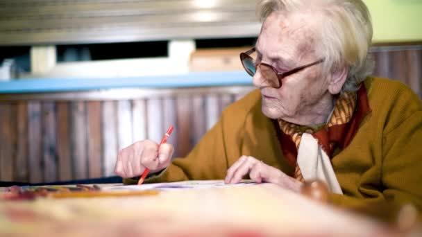 Femme âgée écrivant sur un bout de papier à la maison. Loisirs des retraités — Video
