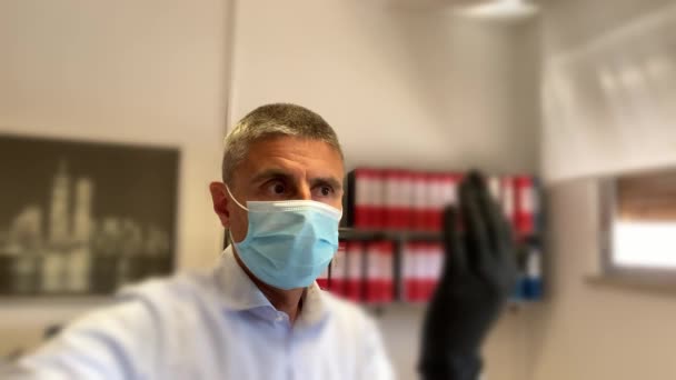 Hombre mirando alrededor de la oficina usando máscara durante el brote de coronavirus, cámara lenta — Vídeos de Stock