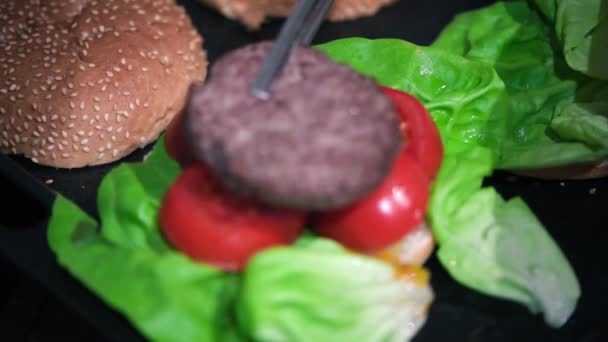 Вкусный бургер с салатом и помидорами — стоковое видео