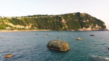 Gün batımında Ischia Citara Sahili 'nde kayalar var. İnsansız hava aracı İtalya üzerinde hareket ediyor.