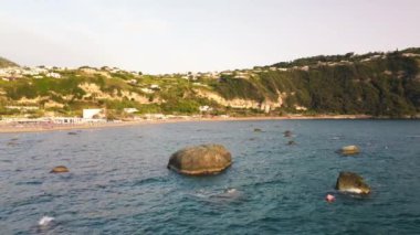 Gün batımında Ischia Citara Sahili 'nde kayalar var. İnsansız hava aracı İtalya üzerinde hareket ediyor.