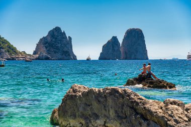 CAPRI, İtalya - 15 Haziran 2021: Turistler ünlü Faraglioni manzaralı Marina Piccola Sahili 'ni ziyaret ettiler