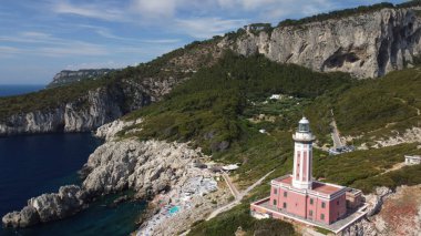Deniz feneri ve Capri Plajı yaz mevsiminde. Hareket eden bir İHA 'dan görüntüle