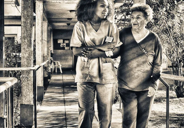 African Female Doctor Talking Elderly Retired Woman Hospital Yard Happiness — Stock Photo, Image