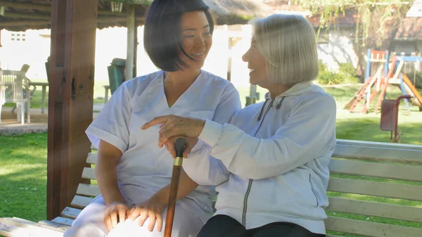 Asyalı Doktor Yaşlı Emekli Bir Kadınla Konuşuyor Kisi Bahçe Bankında — Stok fotoğraf