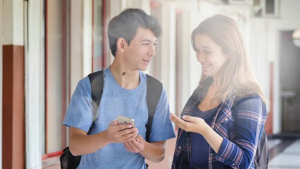 白人青少年情侣在学校里开心地在走廊里聊天 — 图库照片