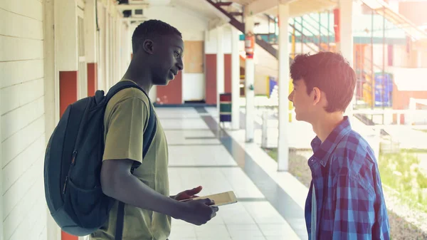 Vita Och Afrikanska Tonårskompisar Som Pratar Skolkorridoren — Stockfoto