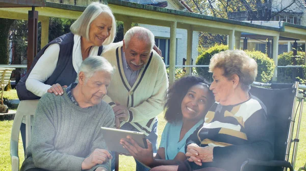African Nurse Using Tablet Two Elderly Retired Couples Outdoor Rehab — Stock Photo, Image