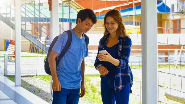 Adolescentes Mirando Teléfono Inteligente Patio Escuela —  Fotos de Stock