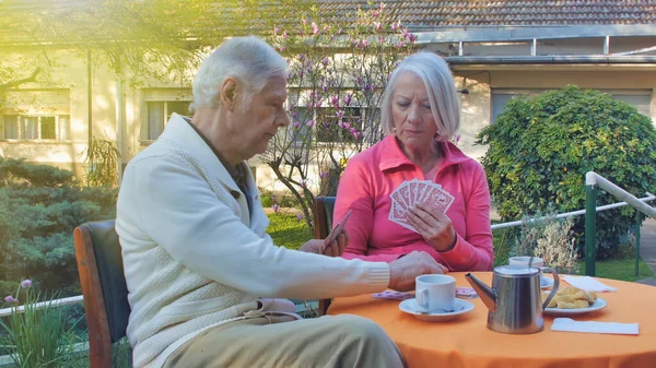 Kaukasisches Rentnerehepaar Beim Frühstück Und Kartenspielen Garten Konzept Für Ruhestand — Stockfoto