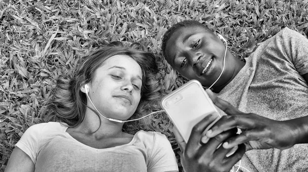 Pareja Multiétnica Adolescentes Acostados Césped Escuchando Música Concepto Felicidad Ligereza —  Fotos de Stock