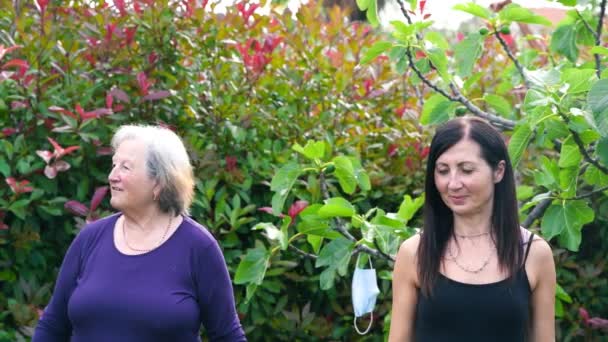 Two women having fitness outdoor with face mask hanging from the trees — Stock Video