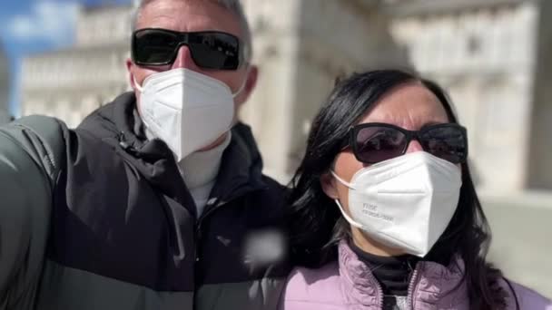 Casal caminhando perto de um marco da cidade usando máscara bucal na pandemia vívida — Vídeo de Stock