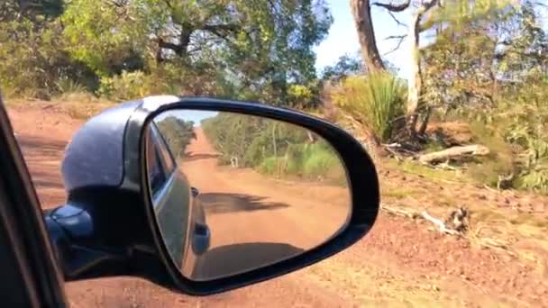 Estrada áspera como visto de um carro em movimento, vista do espelho do carro lateral — Vídeo de Stock