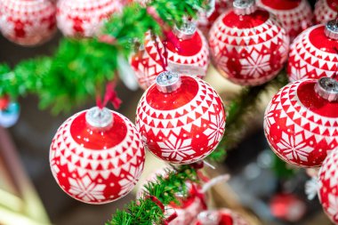 Arka planda yeşil ağaç olan kırmızı Noel topları