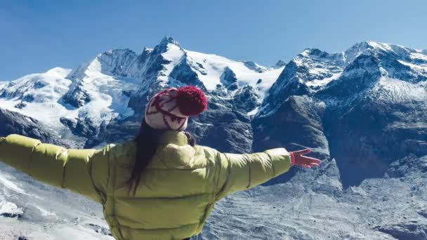 Вид сзади на женщину, обнимающую свежий воздух с горами, покрытыми снегом в летний сезон, Национальный парк Гроссглокнер, Австрия — стоковое видео