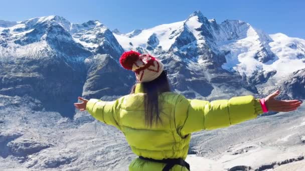 Вид сзади на женщину, обнимающую свежий воздух с горами, покрытыми снегом в летний сезон, Национальный парк Гроссглокнер, Австрия — стоковое видео