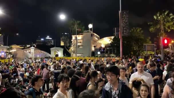 SINGAPORE - DECEMBER 31, 2019: Tourists enjoy the last day of the year along the city streets before fireworks show — Stock Video