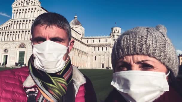 Paar pratende openlucht met gezichtsmaskers voor een oriëntatiepunt. Pandemisch concept — Stockvideo