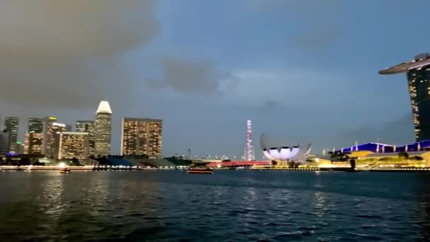 SINGAPORE - JANUARI 3, 2020: Singapore nachtelijke skyline van een veerboot cruise — Stockvideo