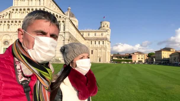 Paar pratende openlucht met gezichtsmaskers voor een oriëntatiepunt. Pandemisch concept — Stockvideo