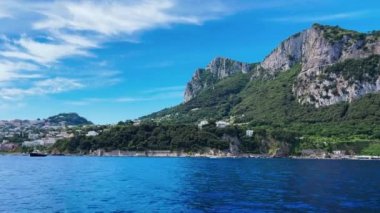 Yaz mevsiminde Capri sahili, İtalya 'da hareket eden bir teknenin panoramik manzarası.
