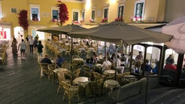 CAPRI, İTALYA - 19 Haziran 2021: Turistler ve yerliler gün batımında ünlü Piazzetta 'nın etrafında yürürler