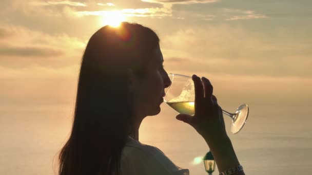 Kobieta pijąca wino o zachodzie słońca z wyspiarskim tłem w sezonie letnim — Wideo stockowe