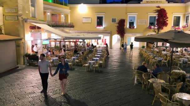 CAPRI, ITÁLIE - 19. června 2021: Turisté a místní obyvatelé při západu slunce obcházejí slavnou Piazzettu — Stock video