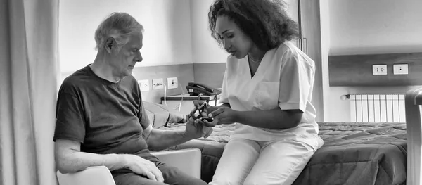 在医院病床上看老年男病人的非洲女医生 康复和退休概念 — 图库照片