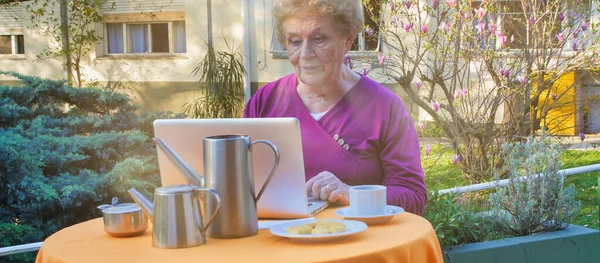 Пожилая Ритуальная Счастливая Женщина Разговаривает Видеокамере Перед Ноутбуком Саду Концепция — стоковое фото