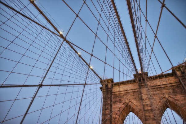 The Brooklyn Bridge at sunset. Upward view of Pylon and cables.