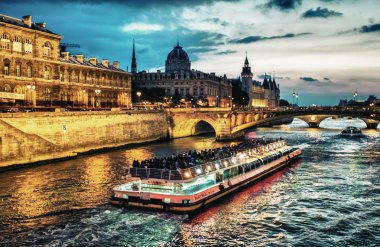 Bateau Mouche Seine nehrinde gün batımında Paris 'te geziniyor.