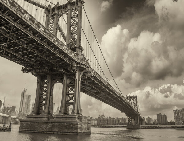 Cloudy evening in New York with Manhattan Bridge side view and city skyline.