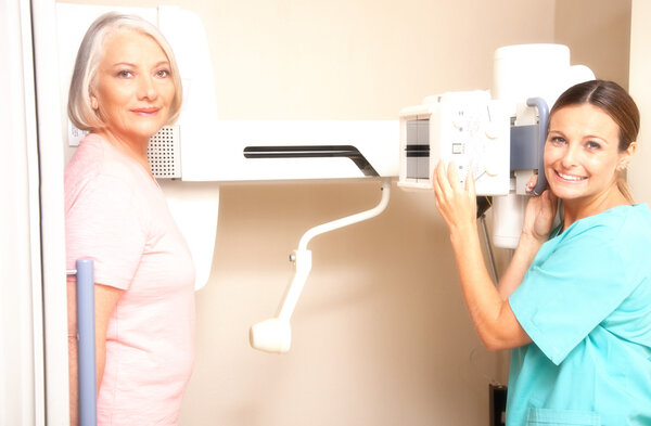 Young female doctor smiling during female patient medical scan