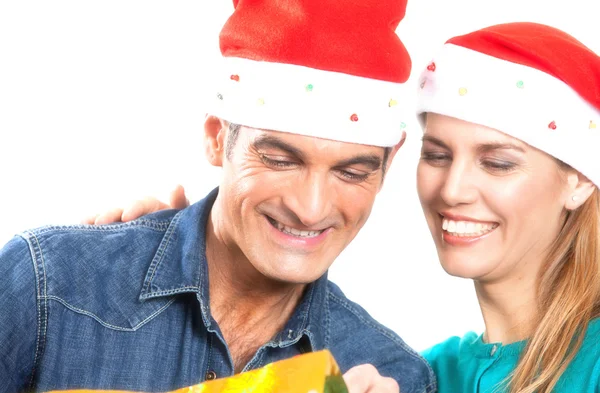 Young happy couple unwrapping a Christmas gift. Isolated over wh — Stock Photo, Image