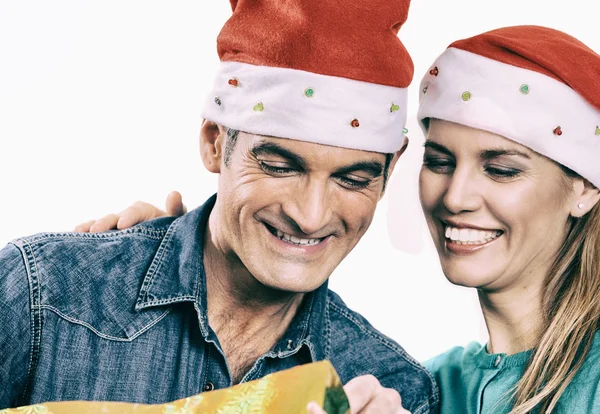 Giovane coppia felice scartare un regalo di Natale. Isolato sopra wh — Foto Stock