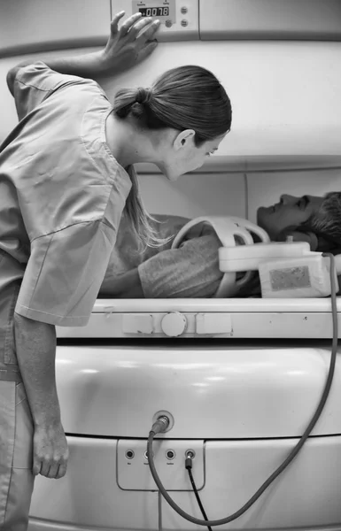 Женщина-врач успокаивает пациента, проходящего МРТ — стоковое фото