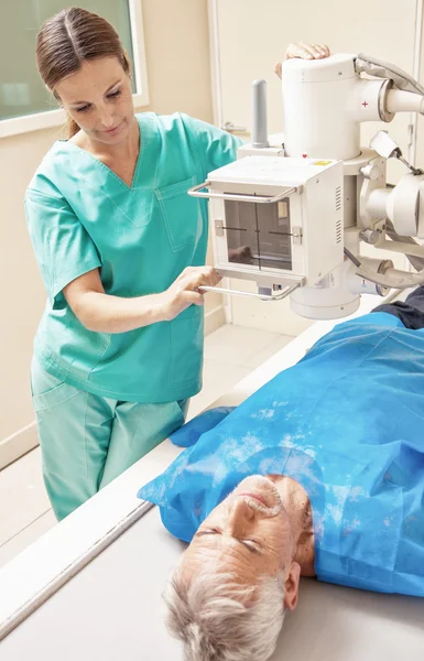 Máquina de raios-X. Médico feminino analisando homem sênior — Fotografia de Stock