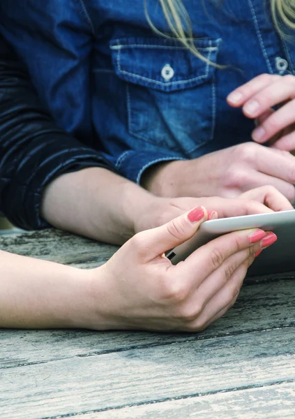 Fille à l'aide d'une tablette extérieure sur une table — Photo