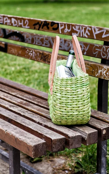 公園のベンチに緑のストロー バッグ — ストック写真