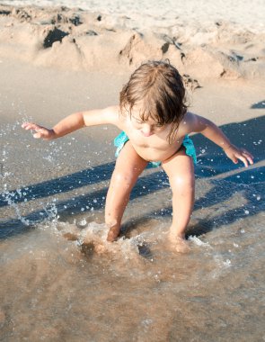 Deniz suyu ile oynayan bebek