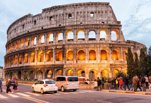 ROME - NOVEMBER 2, 2012: Tourists enjoy Colosseum at night. More than 15 million people visit the city every year..