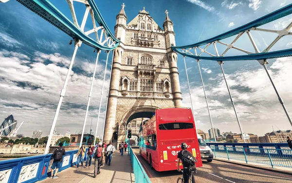 Червоний автобус перетину Tower Bridge, Лондон — стокове фото