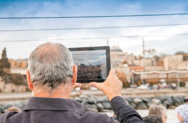 Male tourist capturing image of Istanbul with his tablet clipart