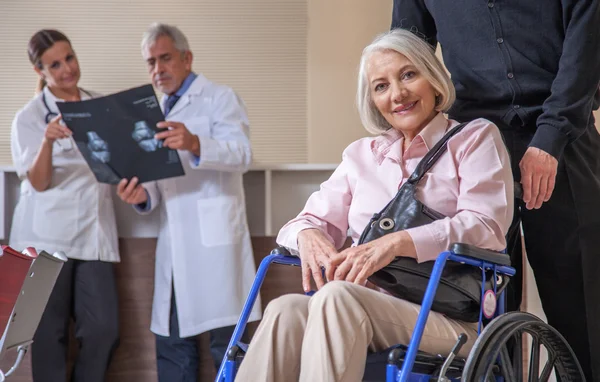 Donna anziana in ospedale con i medici — Foto Stock
